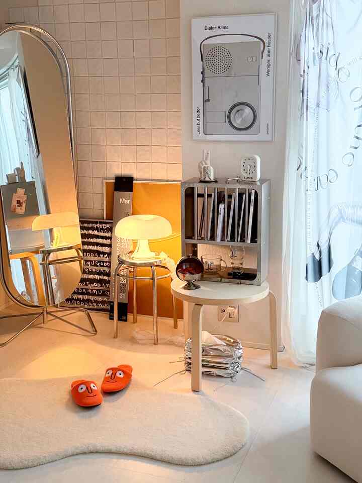 白とシルバーの色調のリビング、金属製家具とテーブルランプが配置されたシンプルでモダンな雰囲気のインテリア