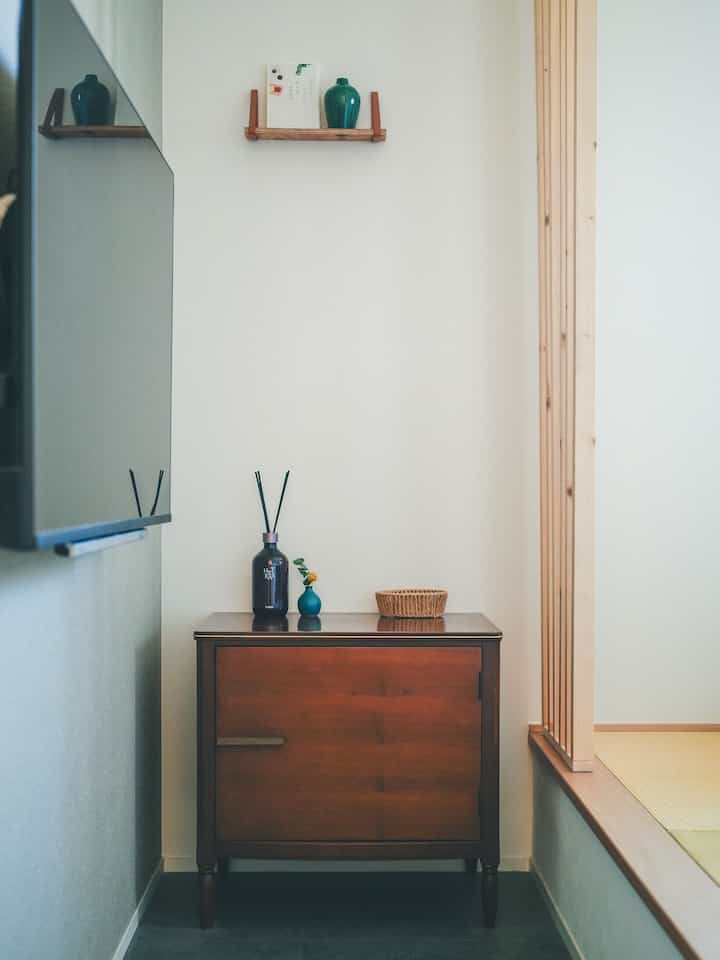 Natural and wood-toned Japanese-style room featuring a small cabinet topped with vases and decor, creating a clean, minimalist vibe