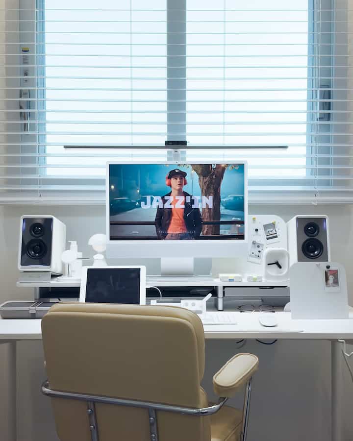 ホワイトとナチュラルカラーの書斎、モニタースタンドとオフィスチェアが配置された清潔感のある在宅勤務空間