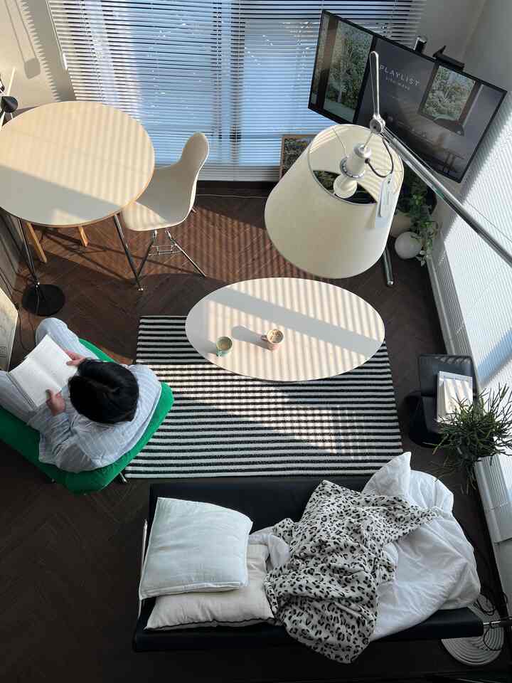 ホワイトとネイビーの色調のリビング、ソファとコーヒーテーブル、読書するアームチェアが配置されたモダンな空間