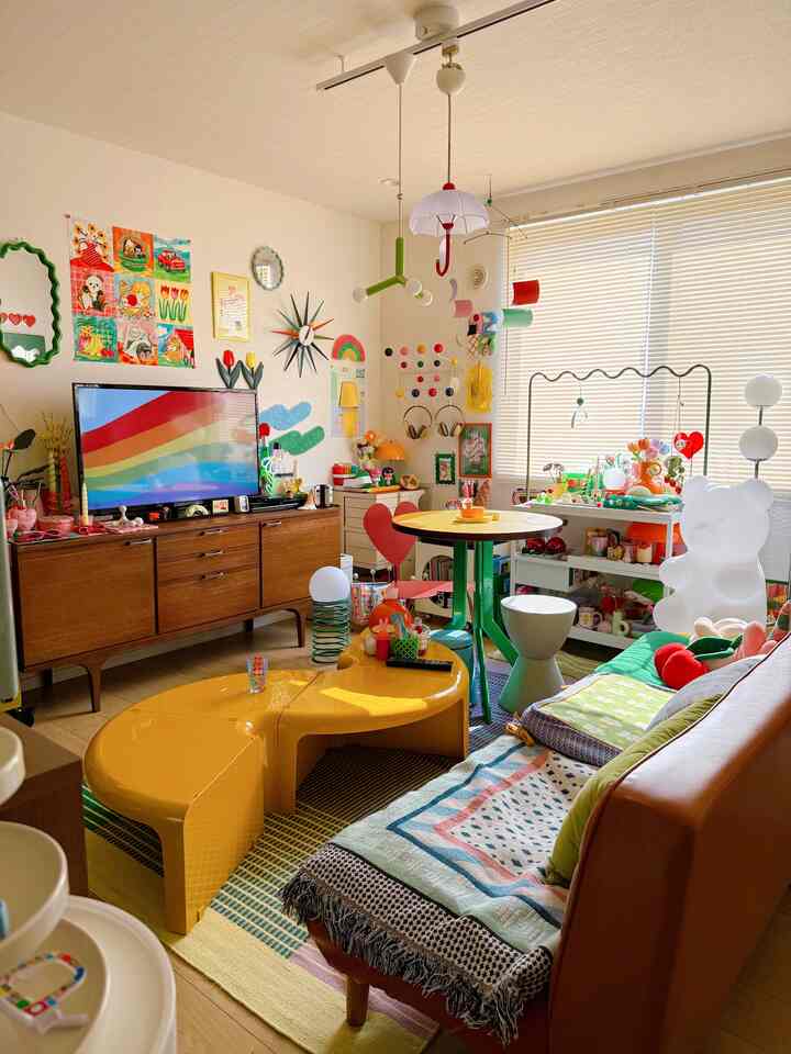 多彩な色調のリビング、黄色のコーヒーテーブルとさまざまな装飾が配置された子供に優しい空間