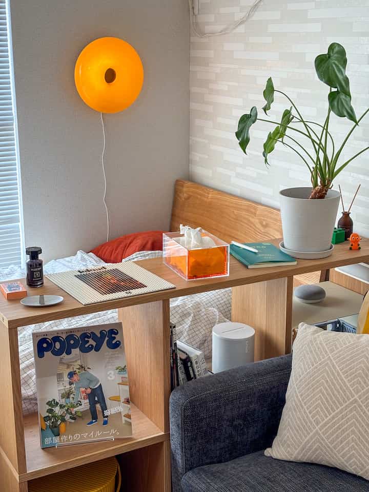 ナチュラルカラーの一人暮らし7畳の部屋、ソファとベッド、植物が配置された雰囲気のあるインテリア