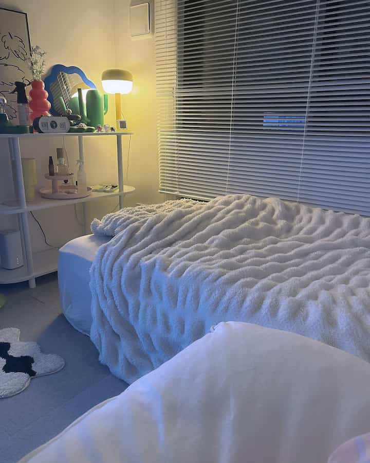 White and gray toned bedroom featuring a thick mattress with soft duvet cover and window blinds, cozy interior ambiance