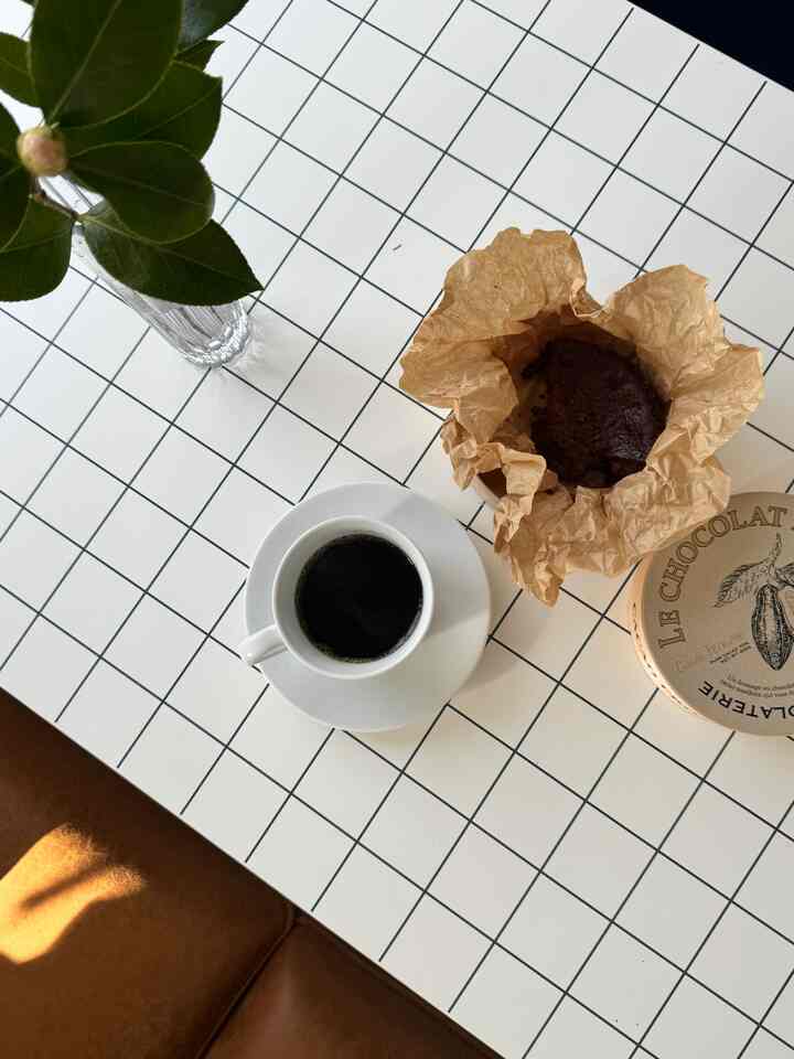 白を基調としたテーブルにシンプルなマグカップとデザートが配置された雰囲気のあるおうちカフェ空間