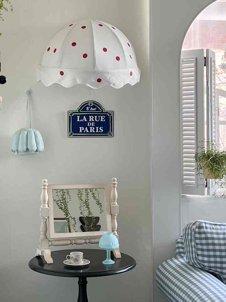 白と青のトーンのリビング、フレンチカントリー風の家具と装飾が配置された雰囲気のある空間