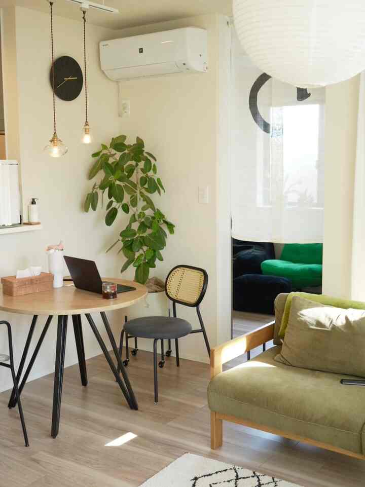 明るい木目調と緑色ソファの北欧風リビング、自然光が温かみのある空間を演出