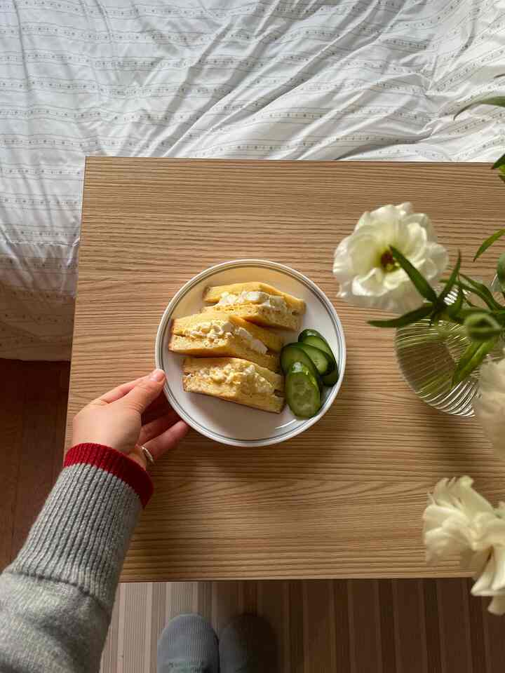 白い寝具と木製テーブルのある8畳ワンルーム寝室、朝食が置かれたナチュラルな雰囲気のインテリア