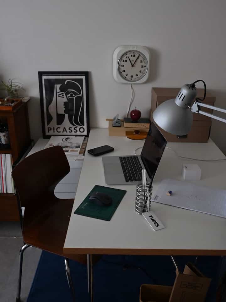 白と茶色のトーンのホームオフィス、ミッドセンチュリーモダンのデスクと椅子が配置された整った作業空間