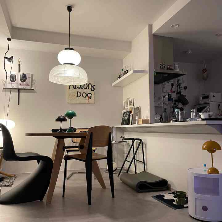 White and natural wood toned single household living room featuring dining table and mixed chairs in a modern setting