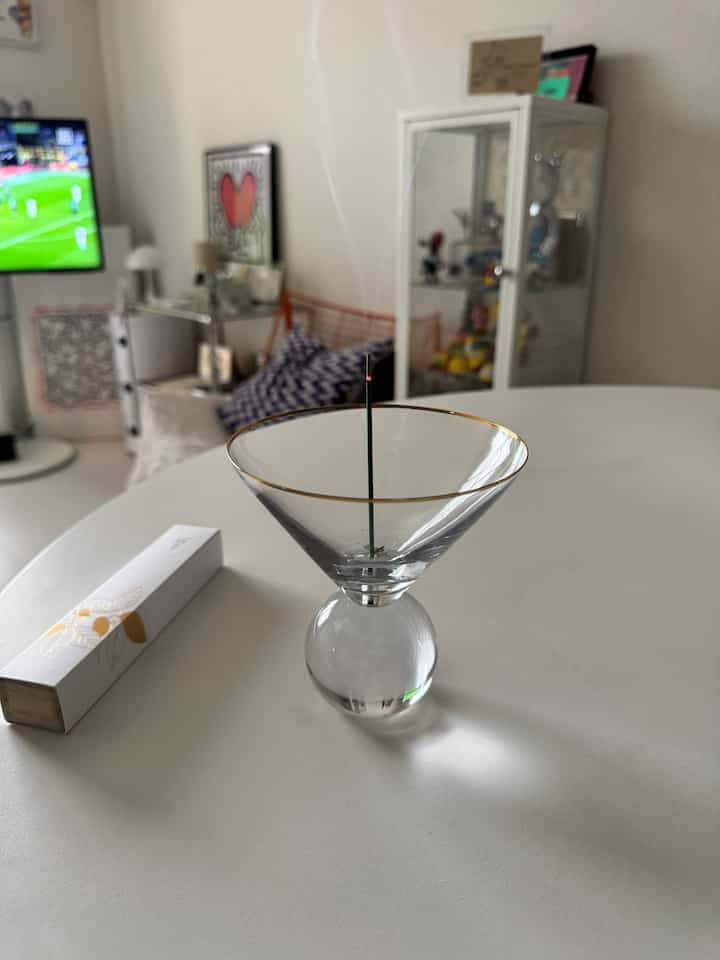 白を基調としたリビング、中央に置かれた白い円形テーブルの上でお香が焚かれ、落ち着いた雰囲気のインテリア