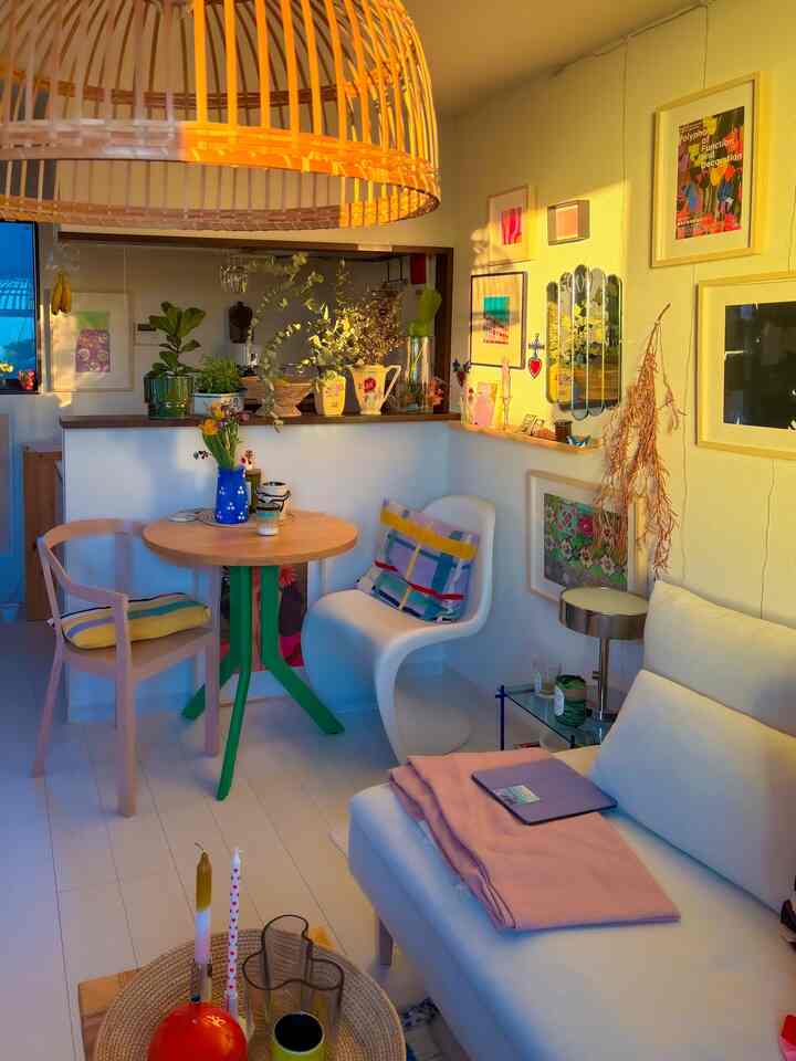 暖かな黄色の自然色調のコンパクトなダイニング、木製のテーブルと椅子、ソファ、植物が配置された雰囲気のある空間