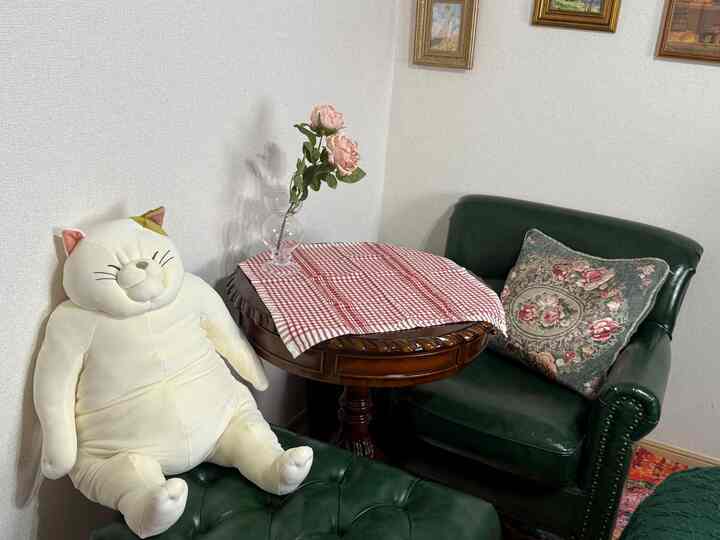 Cozy small room with green leather armchair, wooden round table adorned with checkered fabric, vintage atmosphere
