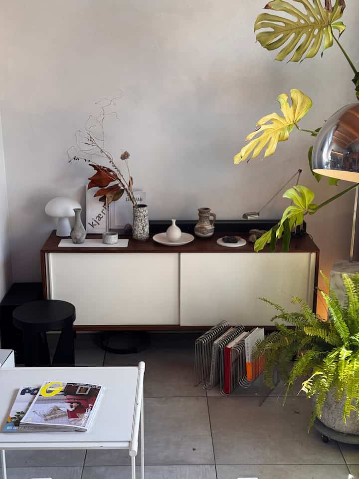 ナチュラルカラーのリビング、木製チェストと植物が配置された落ち着いた雰囲気のインテリア