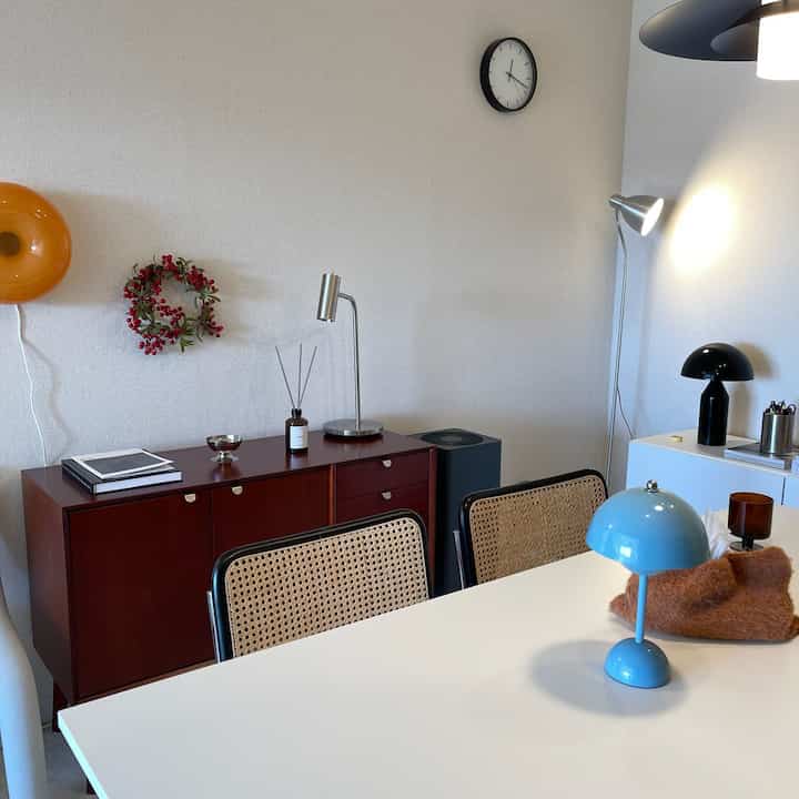 A white table and red storage cabinet in a Mid-Century Modern style living space