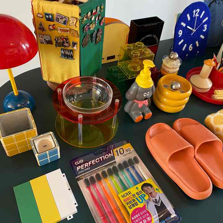 多彩な色合いのテーブルの上に犬の形をした容器と多様なインテリア小物が置かれた雰囲気のある空間