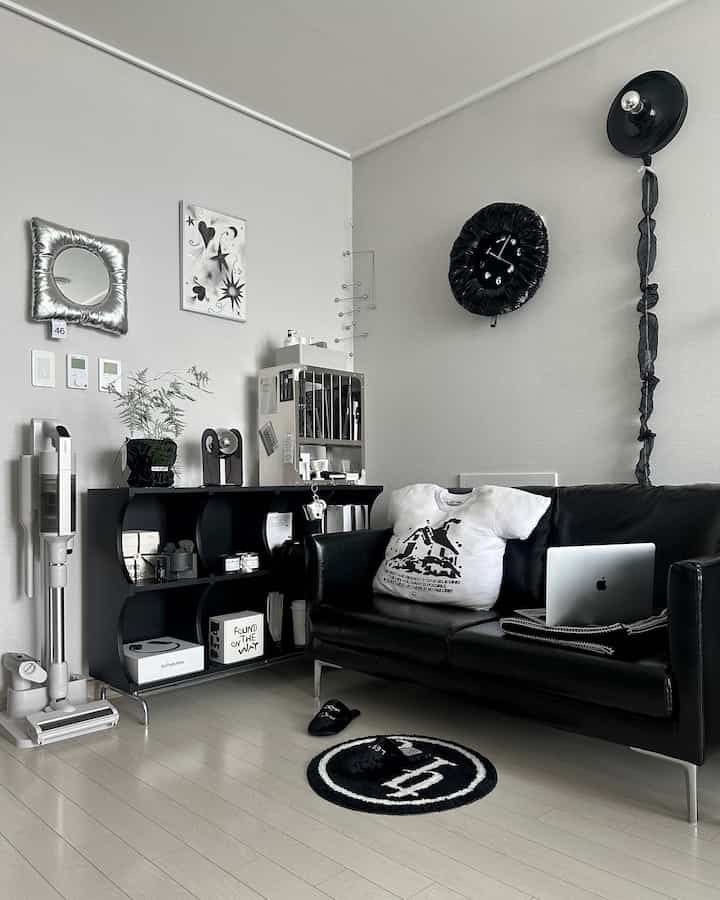 Monotone study space with black sofa and bookshelf, white walls and floor creating a clean, minimal interior
