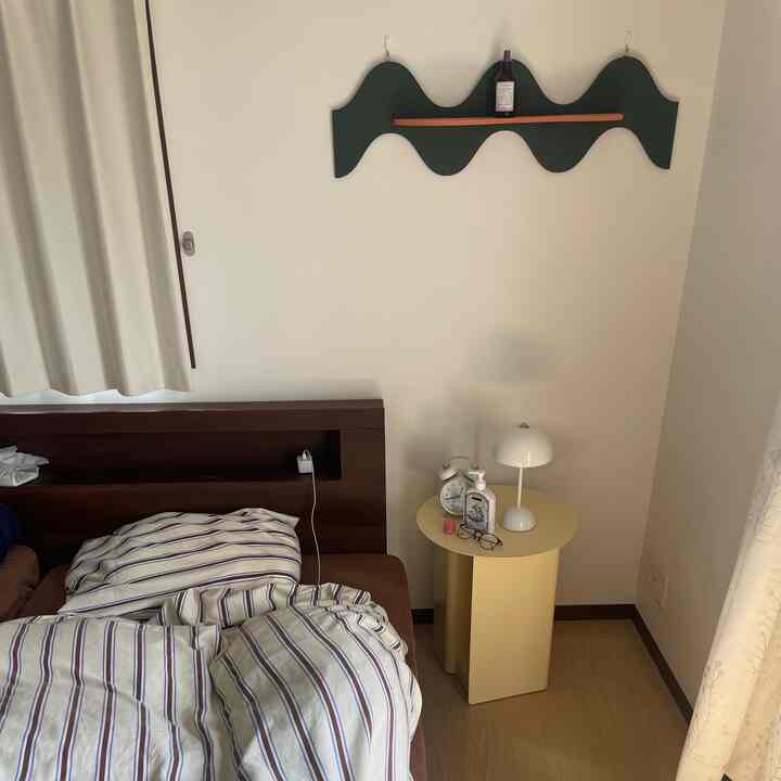 A clean bedroom with white walls, brown bed, and beige nightstand arranged for two-person household