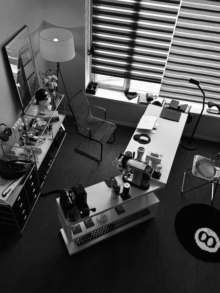 黒と白のトーンのホームオフィス、コーヒーマシンとデスクランプが配置されたモダンなミッドセンチュリースタイルのインテリア