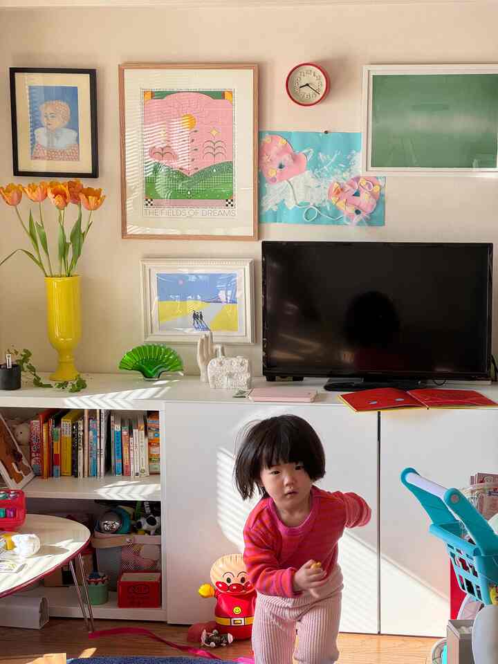 明るいホワイトトーンのリビング、BESTÅの棚とテレビ台が配置され、子供がおもちゃで遊んでいる印象的な空間