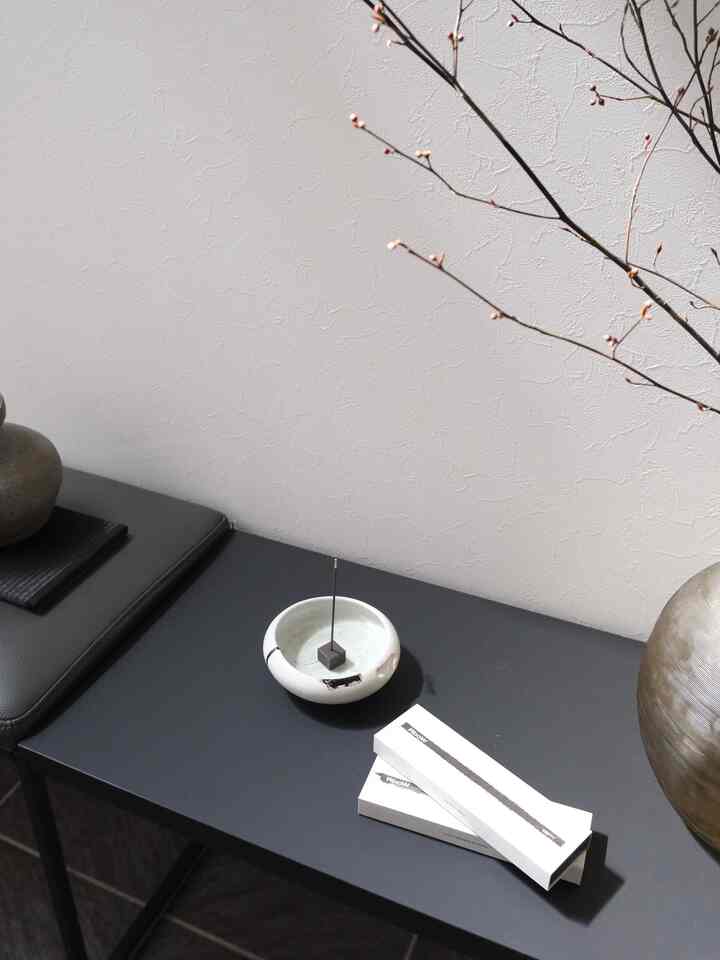 Black and white tone entrance featuring a simple incense stick and objet on a small table with clean Wa-Modern style interior