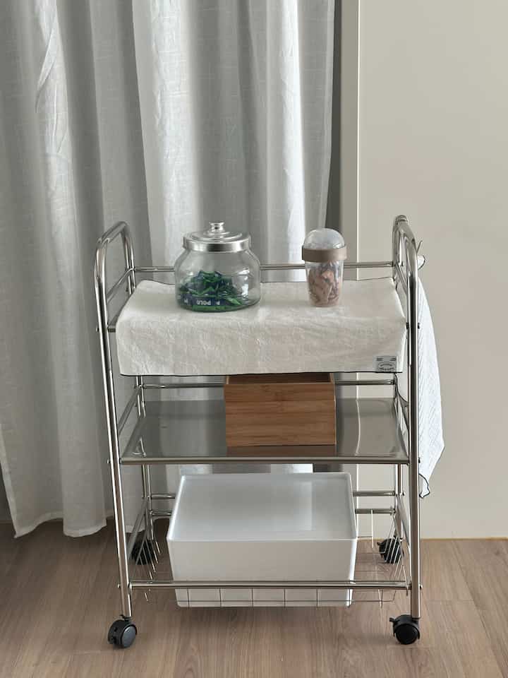 白とステンレス色調のキッチン、整理されたキッチンワゴンが便利な収納アイデアを演出するモダンな雰囲気