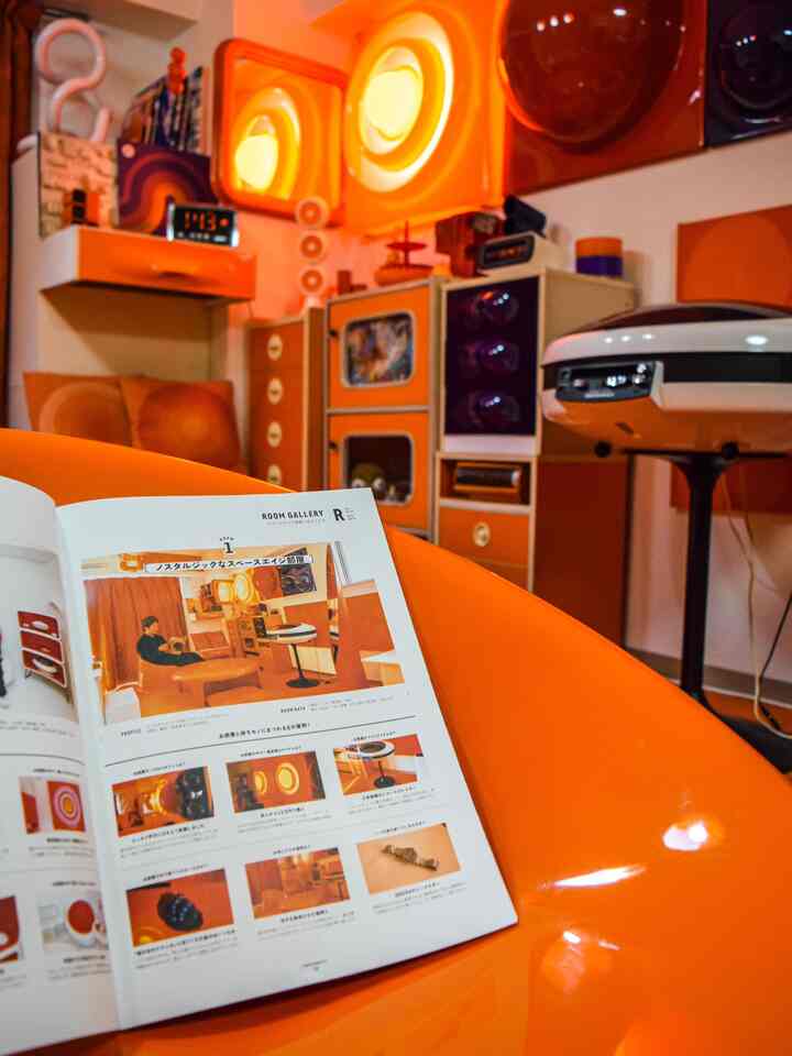 オレンジ色調のミッドセンチュリーモダンなリビング、レトロな家具と照明が配置された雰囲気のある空間