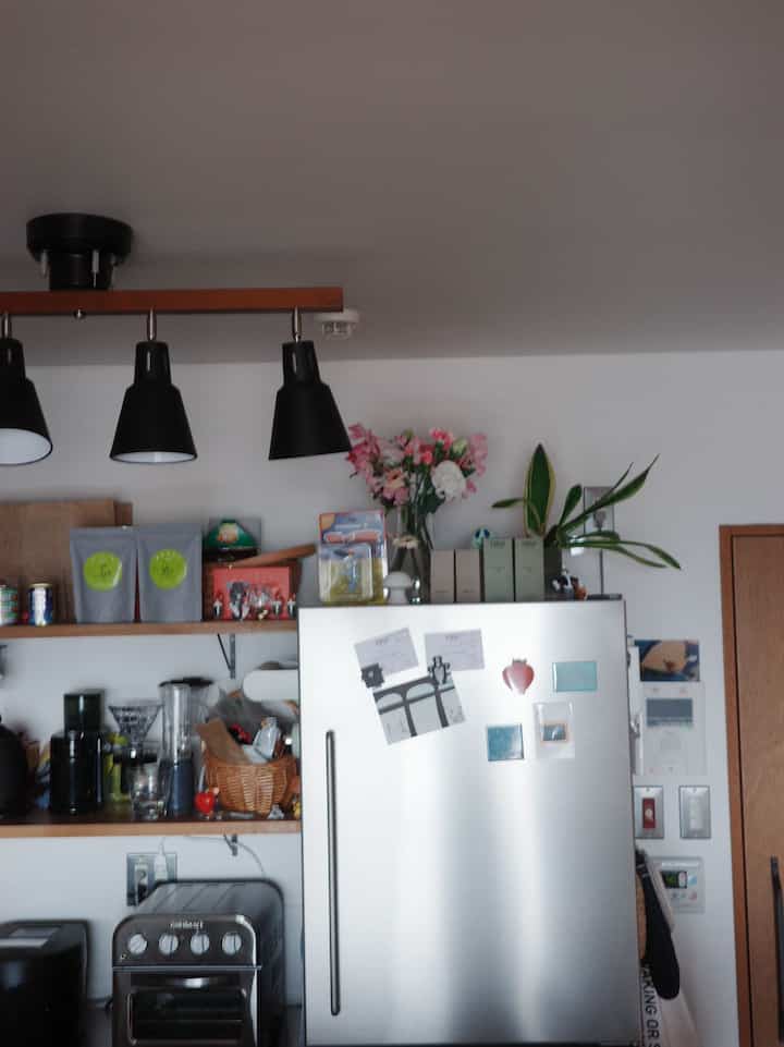 シルバーとホワイトのキッチン、冷蔵庫とオーブントースターが配置された清潔で実用的なインテリア