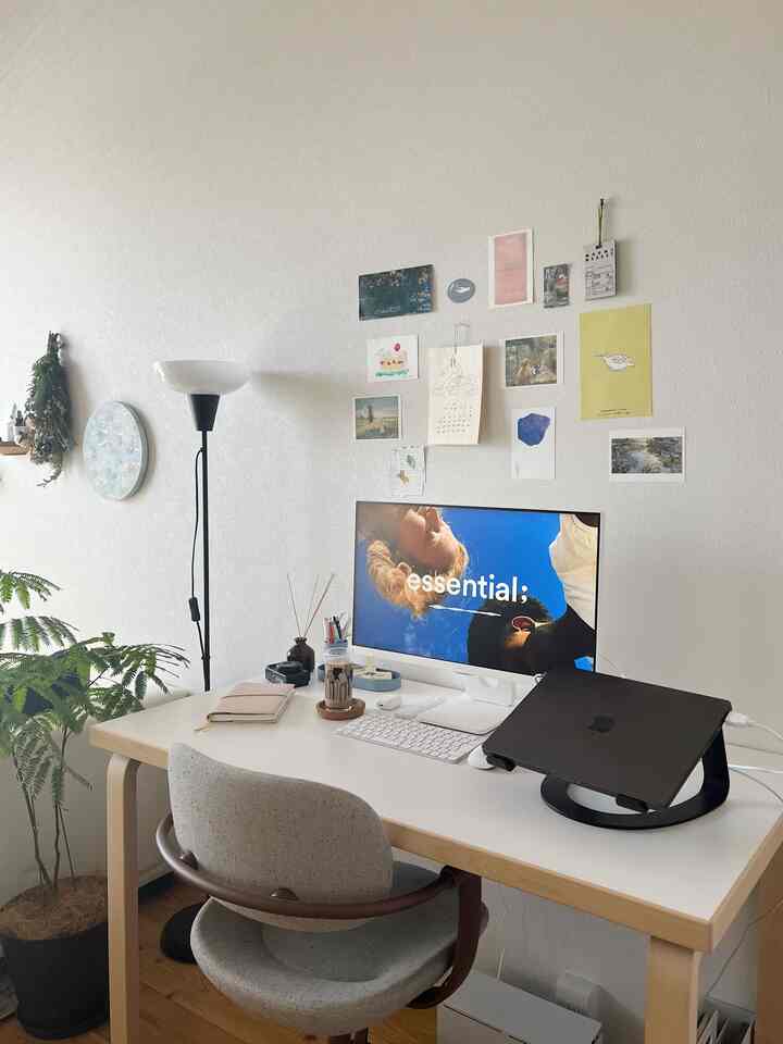 白とナチュラルカラーの調和したワンルームのワークスペース、コンピュータモニターとオフィスチェアが配置された清潔感のある空間