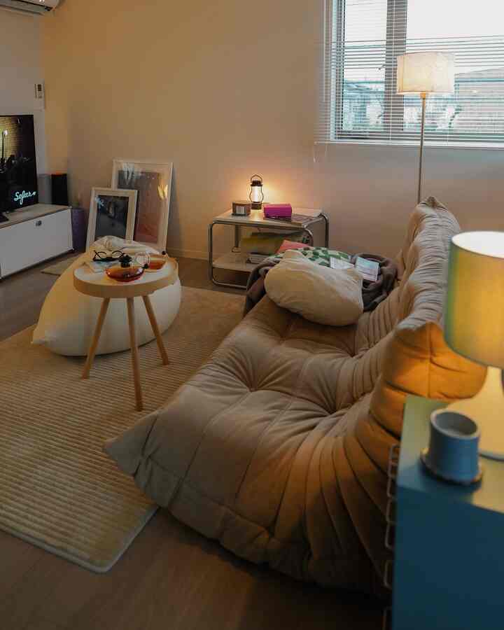 Beige-toned living room featuring a plush sofa and round side table with a cozy, comfortable atmosphere