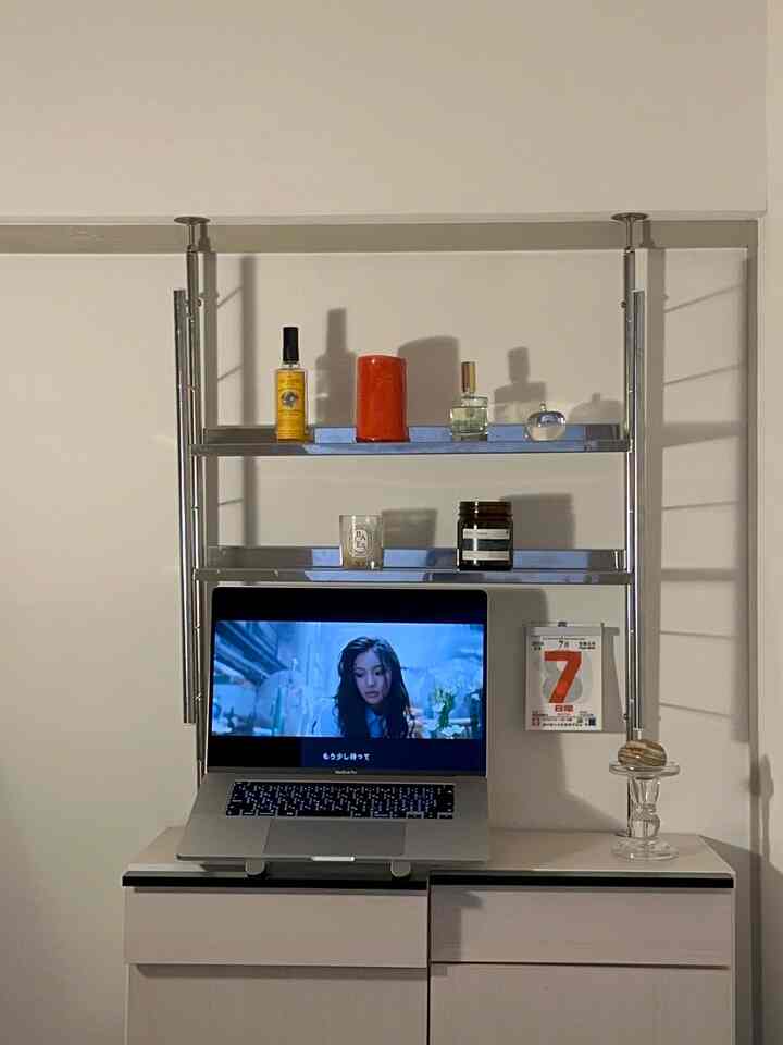 A modern kitchen space with white walls featuring shelves with candles and decorative items in a clean setting