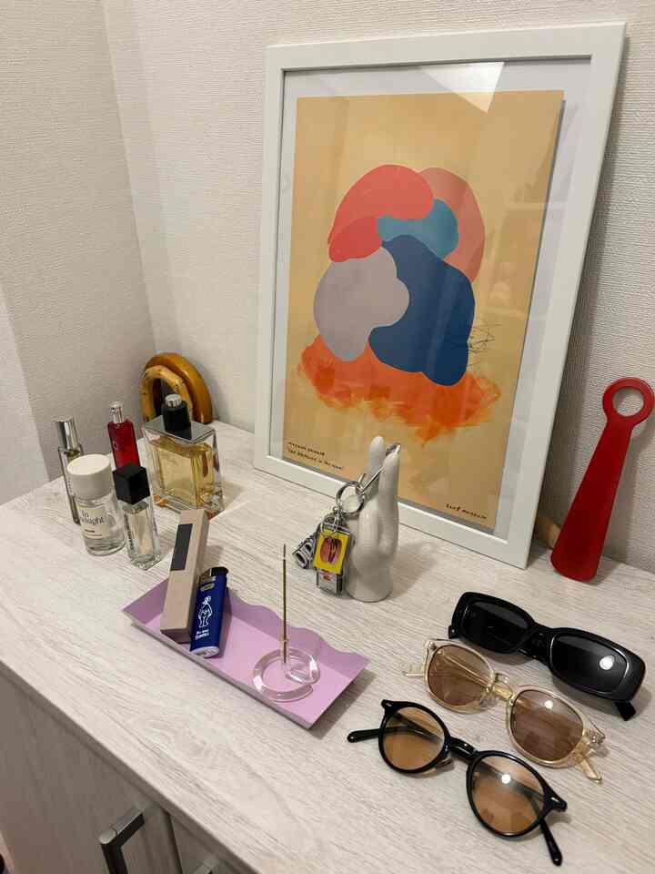 ベージュトーンの玄関、IKEAの収納棚の上に香水、サングラス、インセンススティック、オブジェが配置された落ち着いた雰囲気のインテリア
