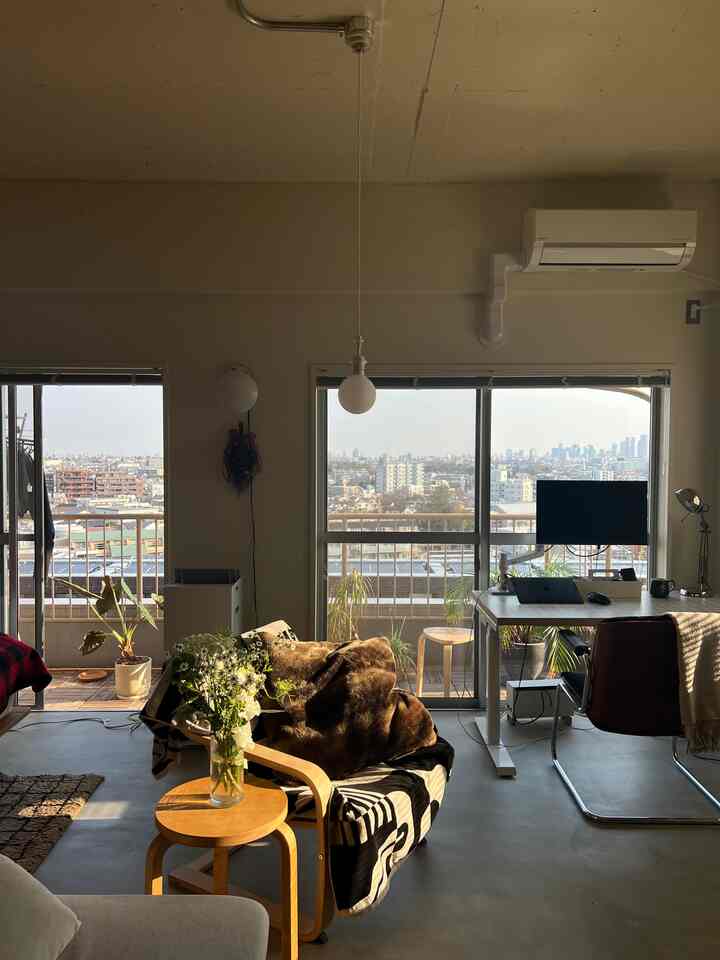 Bright white and wood tone studio apartment with a modern home office and balcony