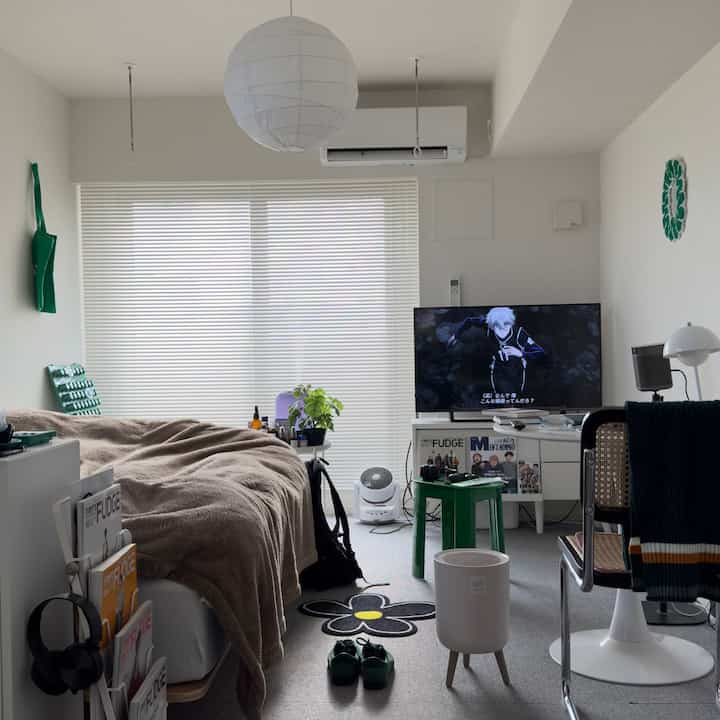 ホワイトとブラウンのトーンのコンパクトな寝室、シングルベッドとテレビ、収納アイデアがある落ち着いた印象的な空間