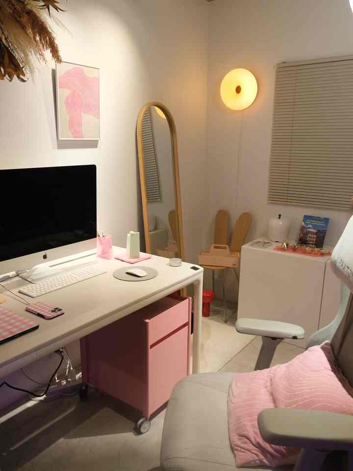 ナチュラルカラーとピンクのアクセントが調和したコンパクトなホームオフィス、すっきりとしたデスクとオフィスチェアが配置された居心地の良い作業空間