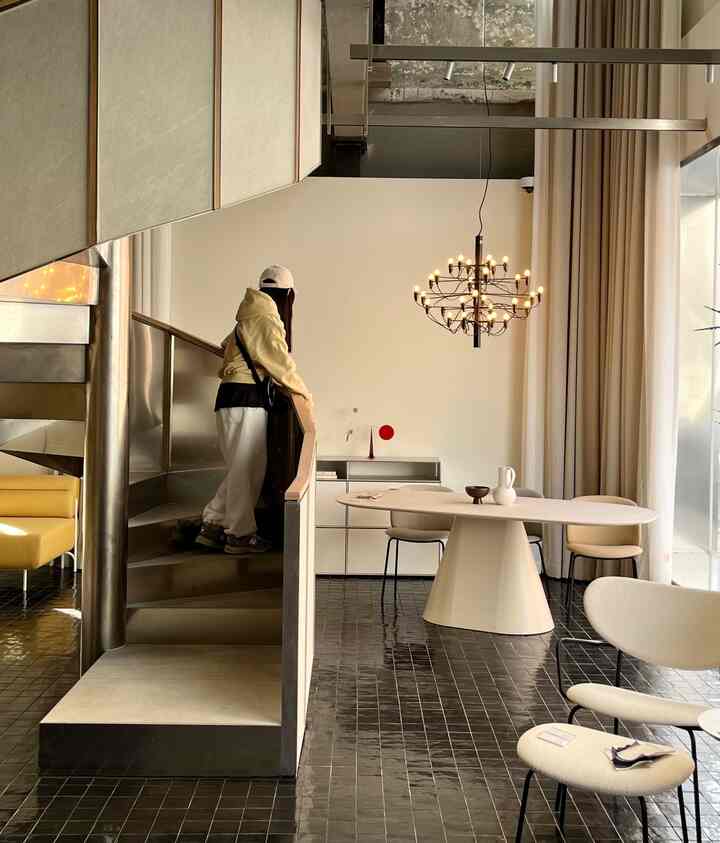 黒いタイルの床と白い壁が特徴のモダンなダイニングルーム、楕円形のダイニングテーブルと椅子が配置された空間