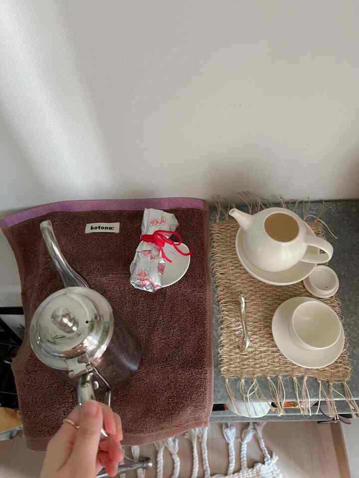 ピンクの縁取りがあるブラウンのタオルの上に置かれた銀色のティーポットが印象的なナチュラルな雰囲気の茶席