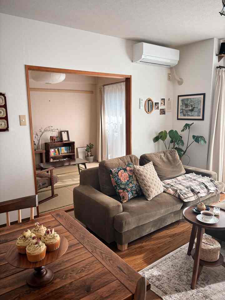 Natural brown-toned living room featuring a vintage sofa and wooden dining table creating a warm atmosphere