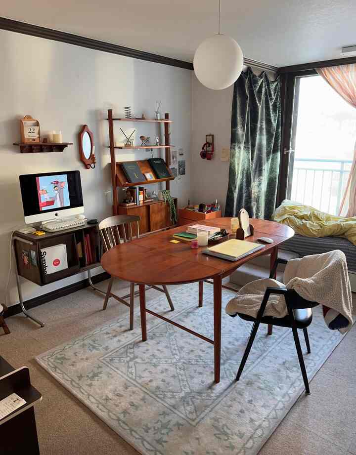 温かみのある木目調のワークスペース兼ダイニング、自然光が差し込む大きな窓のある居心地の良いワンルームインテリア