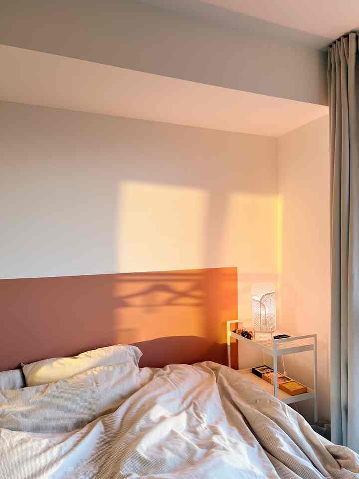 White and brown toned bedroom featuring a duvet cover and table lamp with a cozy, simple atmosphere