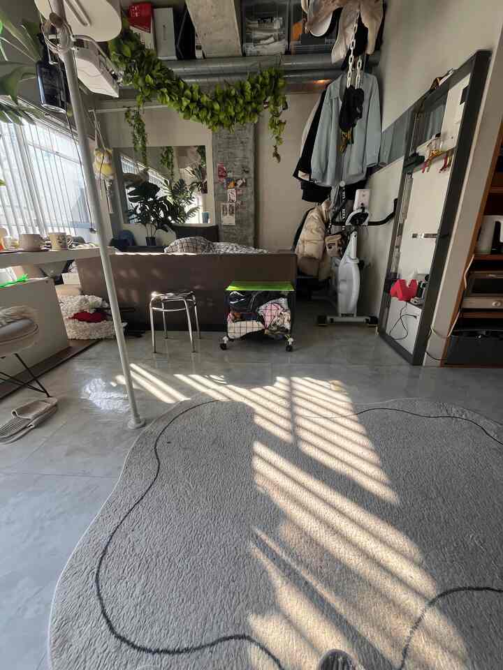 Bright white walls with beige sofa in a compact studio living room featuring practical storage solutions and a modern aesthetic