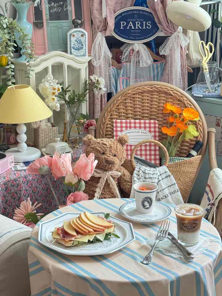 ナチュラルでピンク色調のカフェ風インテリア、ラタンチェアとテーブルセッティングが雰囲気のある空間を作り出す