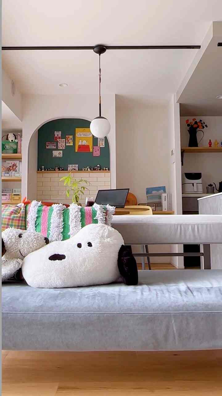 白と緑のトーンが調和するリビングとダイニングルーム、ソファとデスクが配置された落ち着いた雰囲気のインテリア