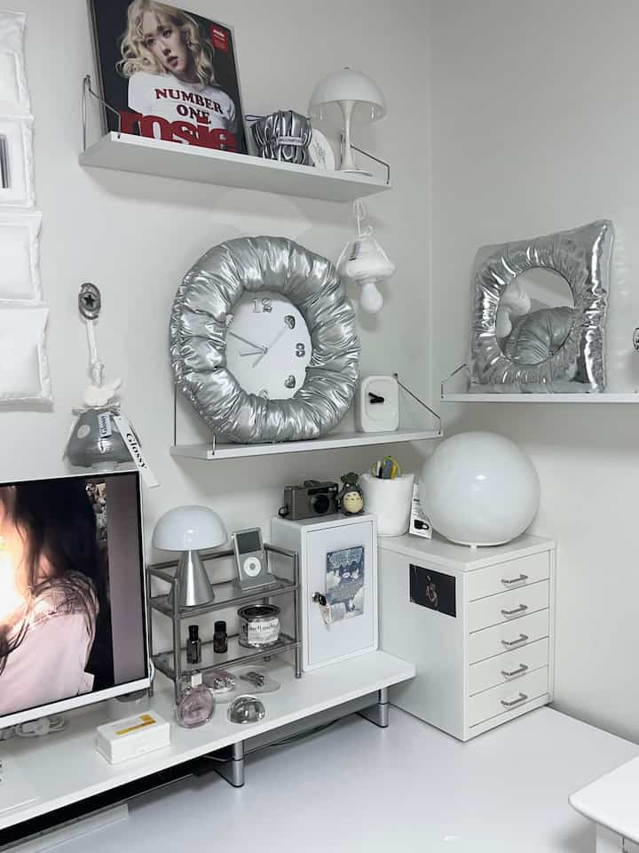 White and silver toned home office space featuring modular shelves and unique silver accessories on a neat desk setup