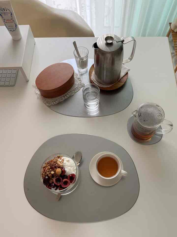 シルバーと白を基調としたキッチンテーブルに、おうちカフェのためのティーセットと軽食が配置された雰囲気のある空間