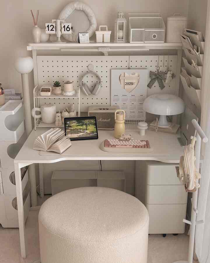 白とベージュのトーンが印象的なホームオフィス、整理されたデスクとスツール、多彩な小物が配置された雰囲気のあるインテリア