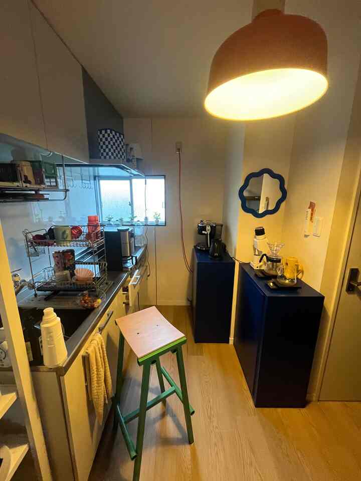 Mid-century modern kitchen featuring blue cabinets and wood tone flooring with an updated coffee zone in a cozy atmosphere