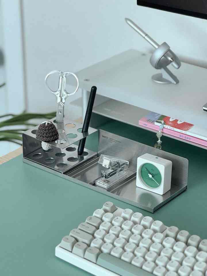 白と緑のホームオフィス、整理されたデスクに時計と文房具オーガナイザーが配置されたシンプルで落ち着いたインテリア