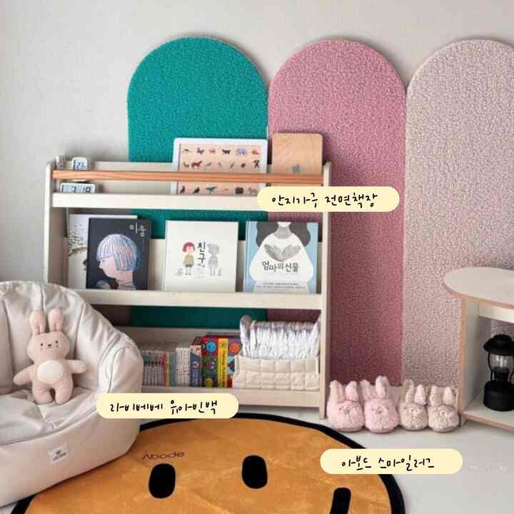 暖かいナチュラルトーンの子供スペース、ラグと幼児用ビーズクッション、本棚が配置された居心地の良い空間