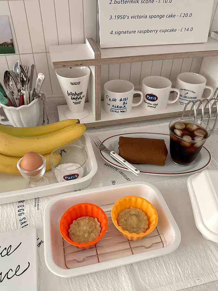 白とベージュの調和が取れたホームカフェキッチン、マグカップとカトラリーが配置された雰囲気のある空間