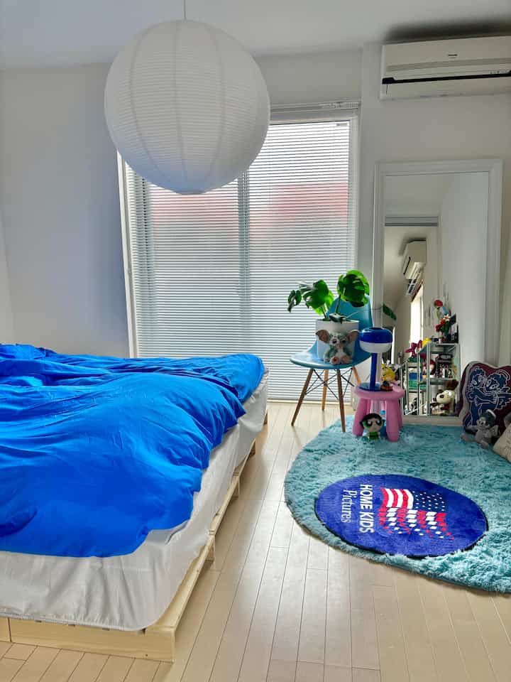 白と青のトーンの寝室、木製ベッドフレームとブラインドが調和するモダンでナチュラルな印象的な空間